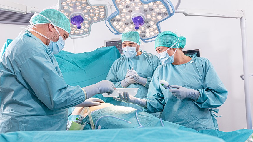 Chirurg neemt een chirurgisch instrument uit een bakje tijdens een ingreep